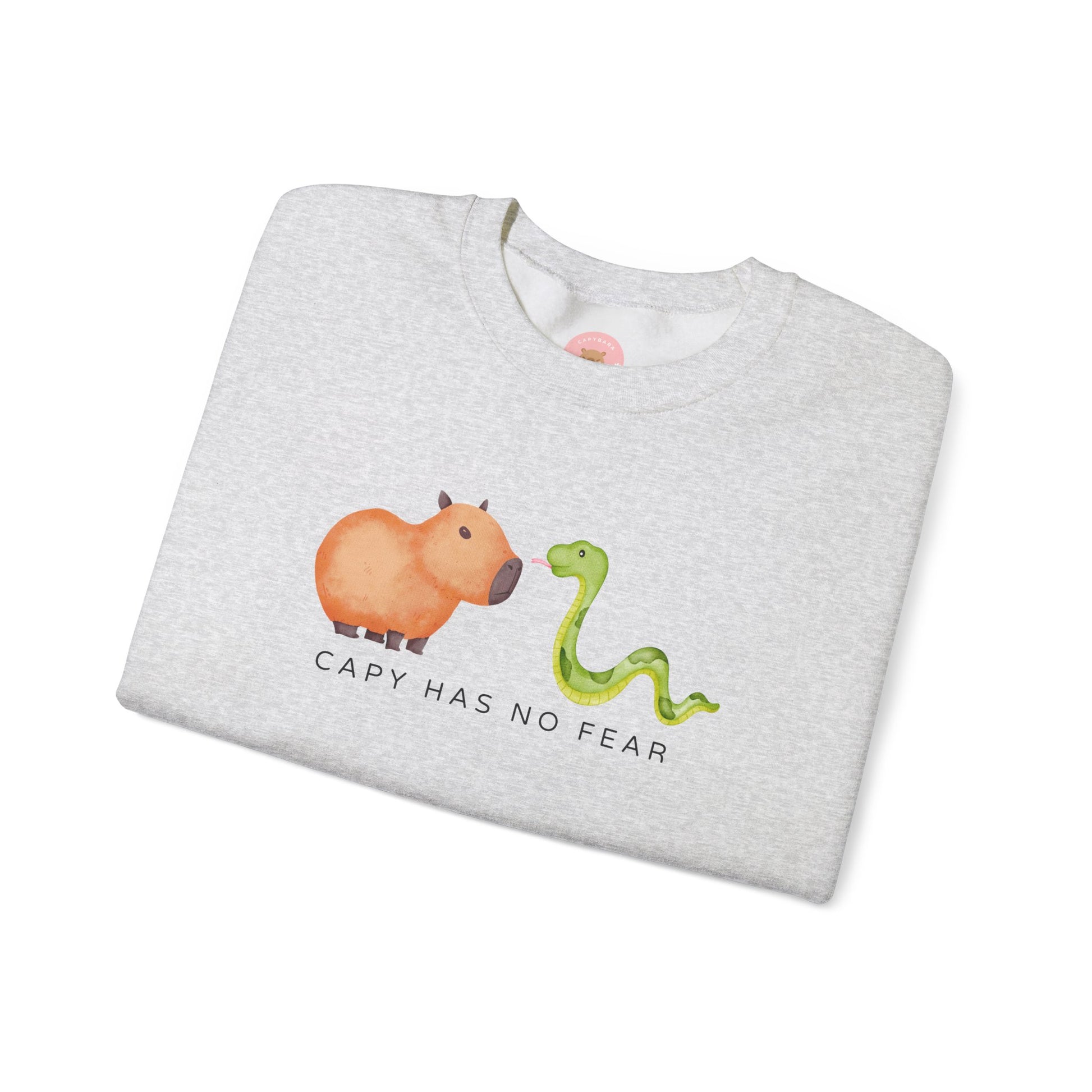 CNY Capybara clothes, Year of the Snake in style with our 'Capy has no fear' Crewneck Sweatshirt! Featuring a bold graphic of a fearless capybara facing a snake, this design is a humorous and symbolic nod to the Chinese New Year. Show off your courage and charm while staying cozy—perfect for family gatherings and festive celebrations!