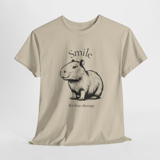 Beige t-shirt with a capybara graphic and text on a white background. Spread good vibes with this heartwarming tee featuring a smiling capybara and the uplifting message: “Smile is a free therapy.” It’s soft, comfy, and perfect for anyone who believes in kindness, chill energy, and capybara-level calm.