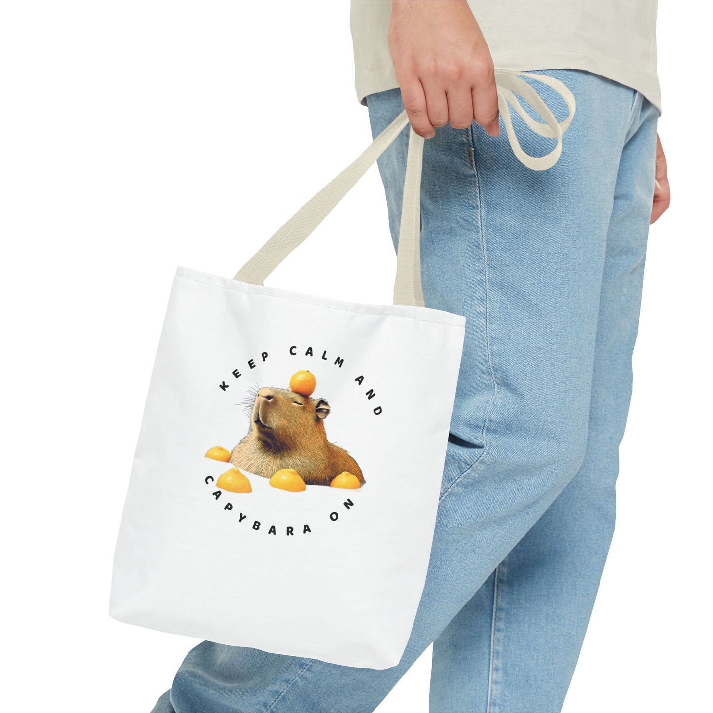 Keep Calm and Capybara On tote bag. Eco-Friendly Tote Bag. Featuring a relaxing capybara enjoying a yuzu bath. It is great for everyday use, carrying groceries or as a fun gift. Made with 100% polyester, a medium-weight fabric that is highly durable.