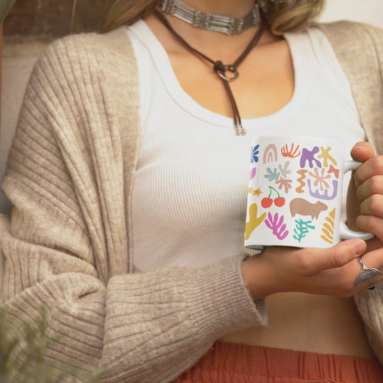 Capybara mug featuring a painting inspired by artist Henri Matisse, with a hidden capybara. Perfect for art lovers and capybara enthusiasts, creating a vibe of abstract chaos. Ideal for cozy mornings or artistic tea breaks. Relevant for art enthusiasts, animal lovers, and those who appreciate unique designs. Perfect for gifting on birthdays, Christmas, or as a thank you present.