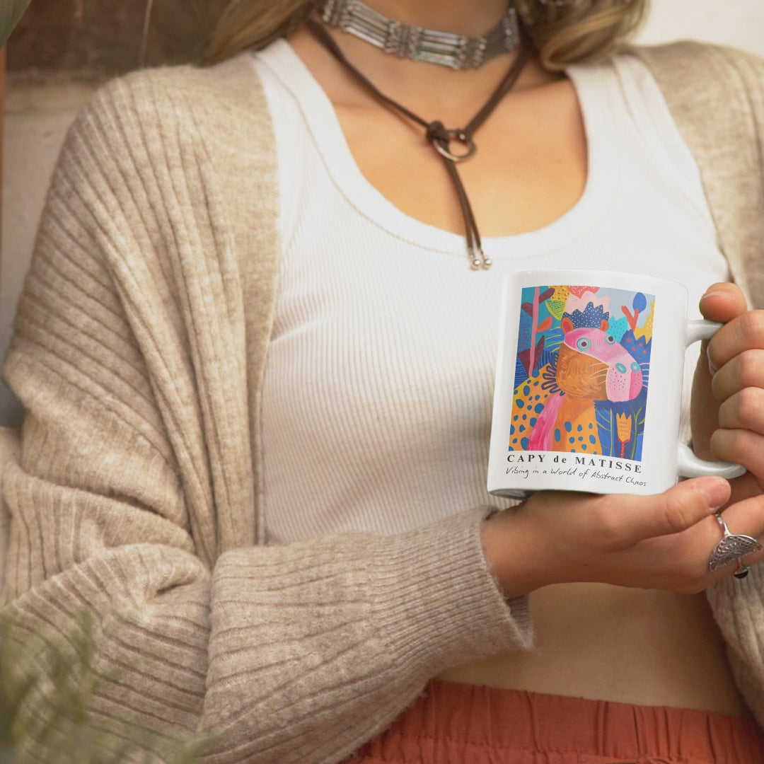 Cute Capybara ceramic mug featuring a painting inspired by artist Henri Matisse, with a silly capybara. Perfect for art lovers and capybara enthusiasts, creating a vibe of abstract chaos. Ideal for cozy mornings or artistic tea breaks. Relevant for art enthusiasts, animal lovers, and those who appreciate unique designs. Perfect for gifting on birthdays, Christmas, or as a thank you present.